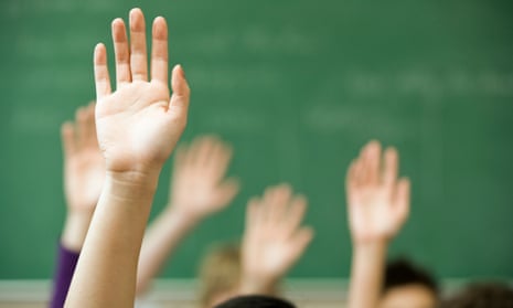 Hands raised in classroom.