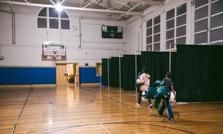 Hai đứa trẻ giúp bố trí chỗ ngủ cho gia đình mình trong phòng tập thể dục tại Trường Cộng đồng Buena Vista Horace Mann K-8 ở San Francisco, California, ngày 26 tháng 1 năm 2022, như một phần của Chương trình Ở lại nhà trường dành cho những gia đình gặp bất an về nhà ở.