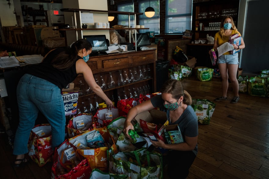 Volunteers for the Covid Care Neighborhood Network pack food into bags at the Queensboro restaurant in Jackson Heights last summer.