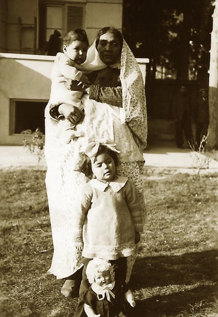 Kamran Afshar in the arms of his nanny, Naneh Sonbol Baji, and Haleh Afshar, standing behind a doll, in Tehran, 1940s. Sonbol Baji, who was of African extraction, was born in a harem and freed in childhood from the court of the last Qajar king, Ahmad Shah (1898-1930). She moved to the home of her future host family, the Afshars, where she grew up, married, and raised her son. She remained there until the end of her life.