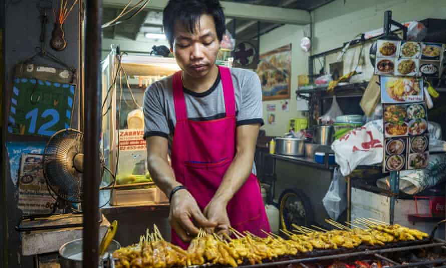 Bangkok, Thailand - A food stall vendor grills chicken ‘’satae Sukhumvit Road