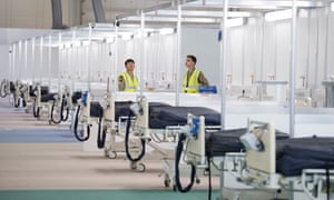 Soldiers and private contractors help to prepare the ExCel centre which is being made into the temporary NHS Nightingale hospital in London.