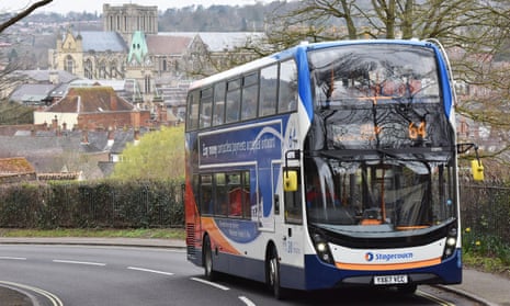 The number 64 bus on its way to Alton, with Winchester Cathedral and city skyline visible in the background.