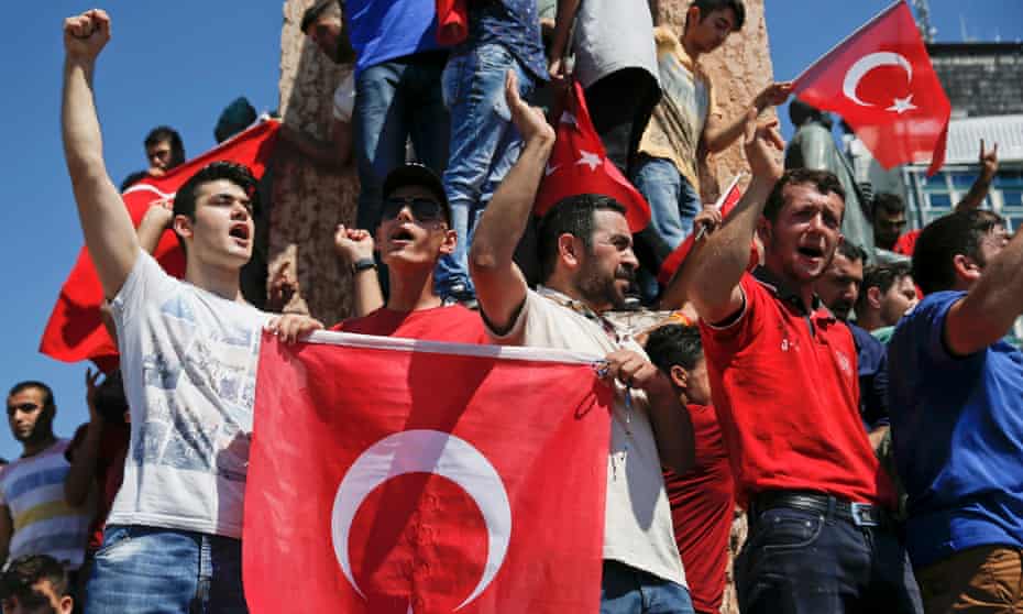 People wave Turkish flags as they gather in Istanbul’s Taksim Square on Saturday.