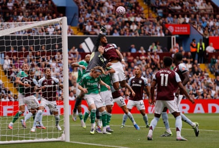 Aston Villa’s Marco Bizot and Tyrone Mings go for an aerial ball