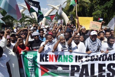 People hold banners and flags as they gather to demonstrate during a pro-Palestine rally in Mombasa, Kenya.