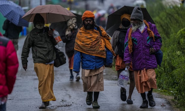 Hindus return from the pilgrimage route after heavy downpours north-east of Srinagar in Indian-controlled Kashmir