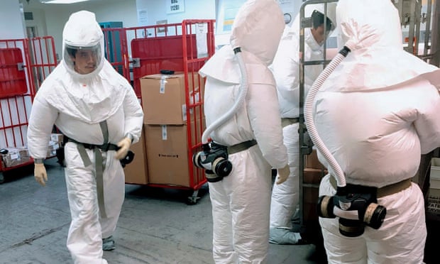 Defense department personnel, wearing protective suits, screen mail as it arrives at a facility near the Pentagon in Washington this week.