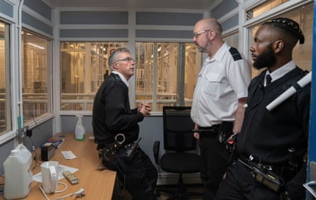 The three men talk in an office