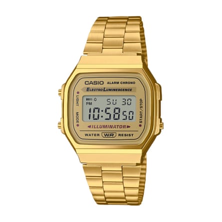 A gold Casio digital watch. The time displayed is 1058. It is on a white background.