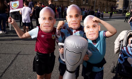 Burnley fans in Vincent Kompany masks celebrate promotion on parade day.