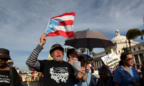 A member of a labor union shouts slogans while holding a Puerto Rico flag during a protest in San Juan September 11, 2015.