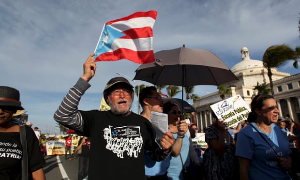 A member of a labor union shouts slogans while holding a Puerto Rico flag during a protest in San Juan earlier this month.