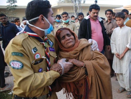 A woman whose relatives were killed in the blast is comforted near the shrine.