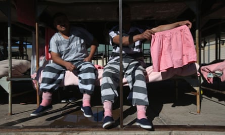 Immigrant inmates show a pair of pink underwear. The striped uniforms and pink undergarments are standard issue at the facility.