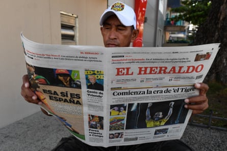 A man reads a newspaper featuring a cover story about the election