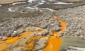 Bright orange streams flowing in the middle of a vast mountain range