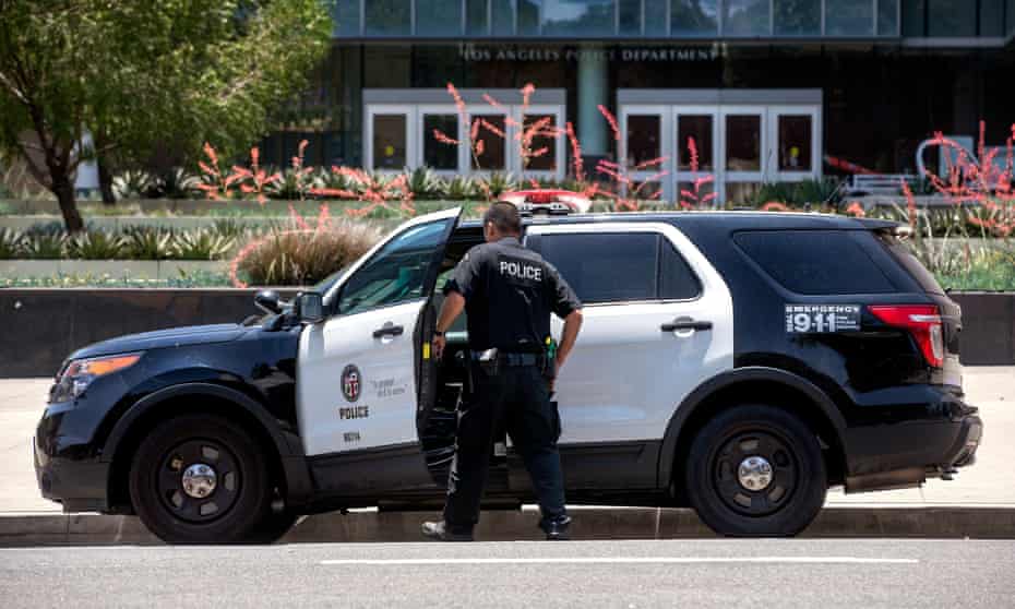 A member of the LAPD gets into his patrol car parked in front of LAPD Headquarters on 1st St. in downtown Los Angeles.