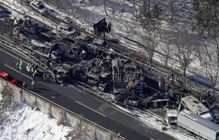 Overhead view of blackened vehicles on an expressway with snow on the ground on either side