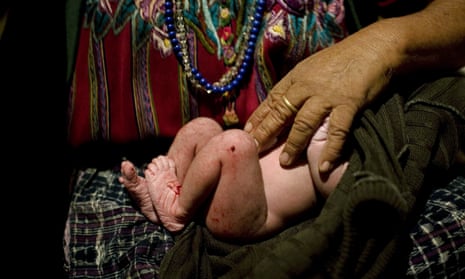 A rural midwife holds a newborn baby in El Llano, Guatemala, where rural midwives deliver six of 10 babies.