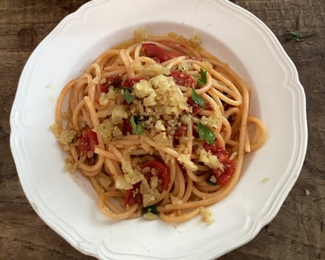 A white plate holds spaghetti with semi-dried tomatoes, herbs, and breadcrumbs, viewed from above. YES it's Rachel Roddy's spaghetti with semi-dried tomatoes, garlic, herbs and breadcrumbs