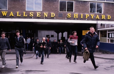 People walk out of a building which has a 'Wallsend Shipyard' sign.