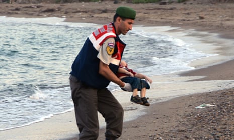 A Turkish police officer carries the body of Alan Kurdi.