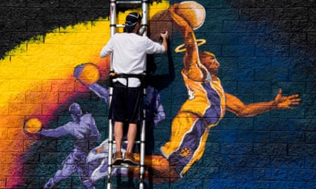 Artist Kiptoe helps paint a mural as a memorial to Kobe Bryant in West Hollywood, California.