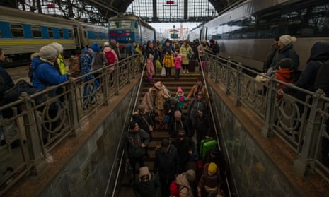 Refugees arriving in Lviv on evacuation trains from Kharkiv and Kryvy Rih make their way through the train station.
