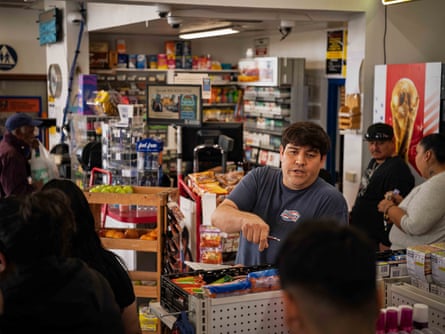 A man speaks to his customers at a convenience store