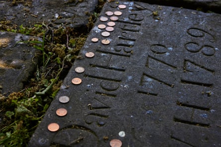 Modern coins are left on the gravestone of David Hartley.