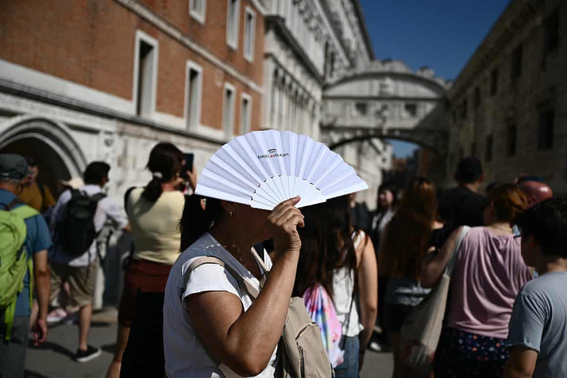 A woman protects herself from the sun with fan