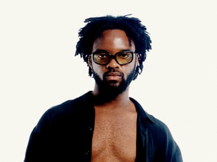 A man wearing glasses wearing an open black top
