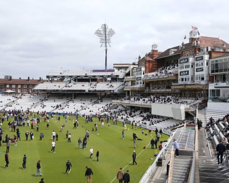 Spectators take a stroll across the pitch during lunch at the Oval.
