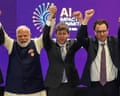 Narendra Modi, Sam Altman and Dario Amodei stand with their arms raised on a stage