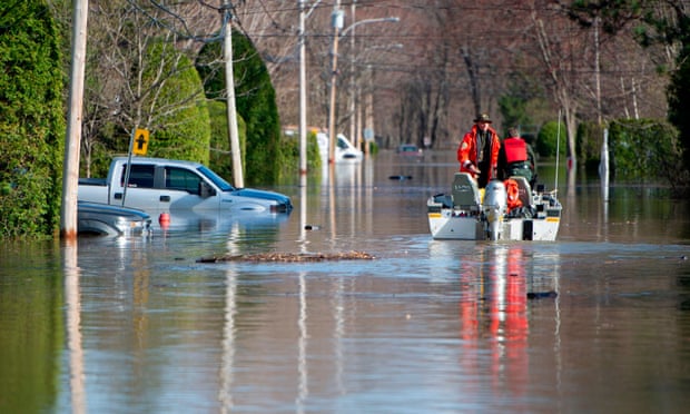 Canadian police in a flooded street in Sainte-Marthe-sur-le-Lac in the suburbs of Montreal. Experts say the floods show Canada has not done enough to prepare for such disasters.