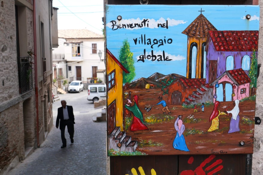A sign in Riace reading ‘Welcome to the Global Village’, put up before Italy’s new far-right government cracked down on the town’s pro-immigration model.