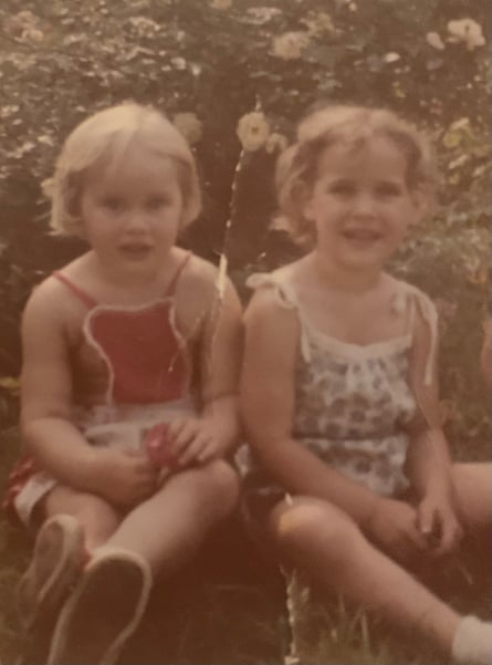 two small children seated outdoors among flowers