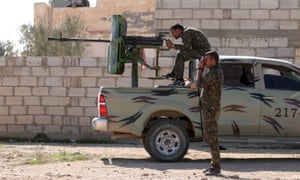 Syria Democratic Forces fighters look through a gunsight and a pair of binoculars