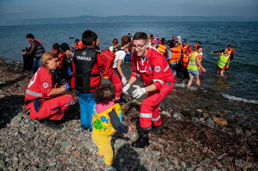The refugees are greeted by aid workers.