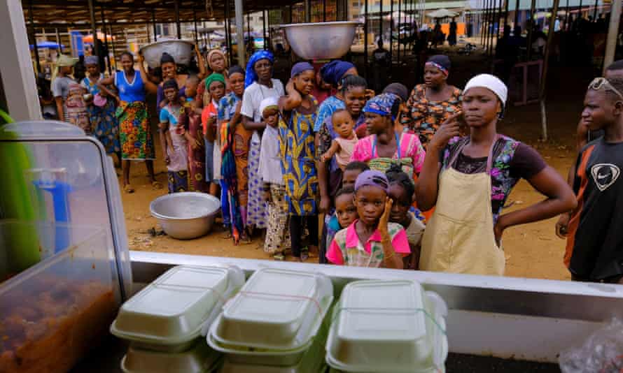 People line up to receive a free lunch from the Food For All Africa organization in Accra on 3 June.