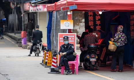 A security guard sits next to the checkpoint near the entrance of Yaotai, an area close to the African Village in Guangzhou.