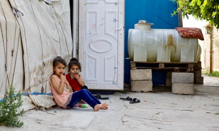 Two children sitting on the ground in Shariya camp.