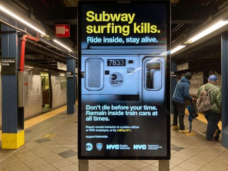 a digital billboard reads ‘subway surfing kills’