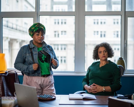 Two women, one standing, one sitting at desk