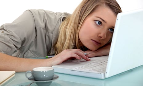 Woman bored in front of a laptop on a desk