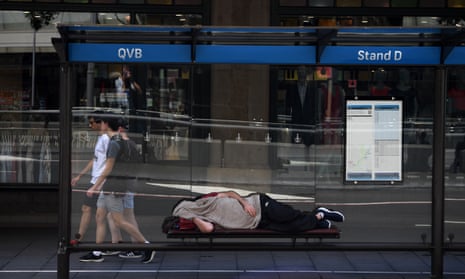 A man is seen sleeping in a bus shelter outside the Queen Victoria Building in Sydney.