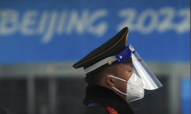 A Chinese paramilitary policeman wearing a face shield and mask to protect from the coronavirus stands guard at an entrance gate to a barricaded Main Press Center (MPC) for the Winter Olympic Games in Beijing