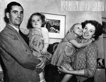 Newcastle centre forward Jackie Milburn with his wife Laura and daughters Linda (3) and Betty (2) in front of a picture on the wall of Milburn shaking hands with King George VI at the 1951 Cup Final, when his goal won the Cup for Newcastle.