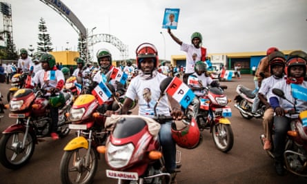 Moto taxi drivers hold flags of the governing Rwanda Patriotic Front at the start of a parade in Kigali.